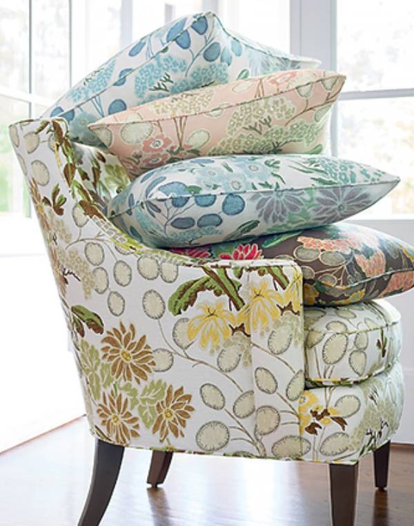 luxuriously upholstered chair stacked high with colorfully patterned pillows with fabrics from Thibaut at Gables New York near Staten Island, NY