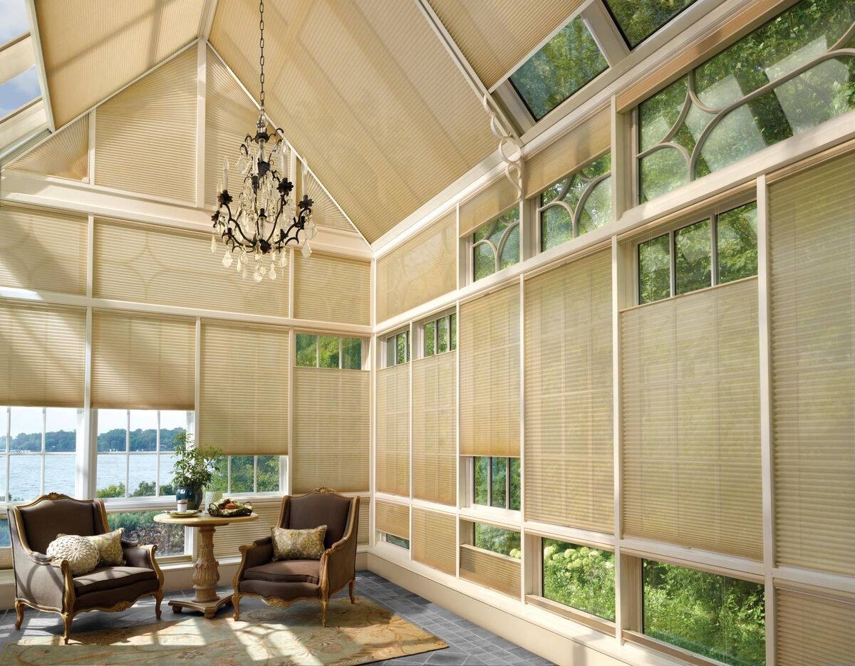 Bright sunroom with many windows decorated with Hunter Douglas Duette® Cellular Shades near Staten Island, NY